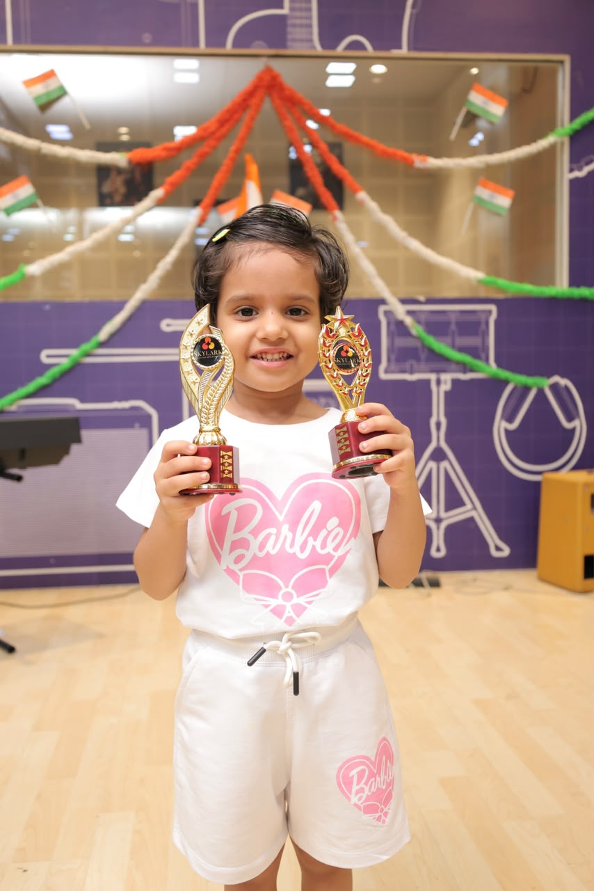 Skylark student holding trophies