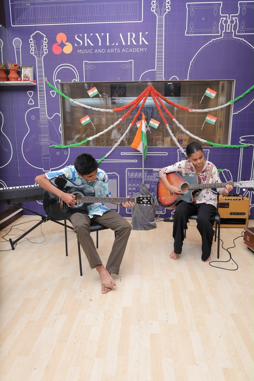 Two Skylark students performing on acoustic guitars in the academy studio